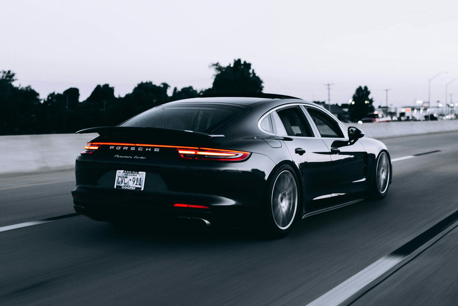 A black executive saloon on an open road at dusk