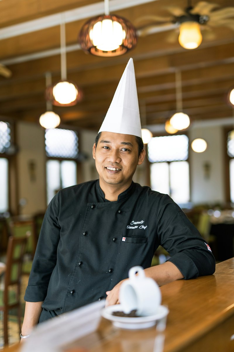 A head chef in whites standing in his restaurant