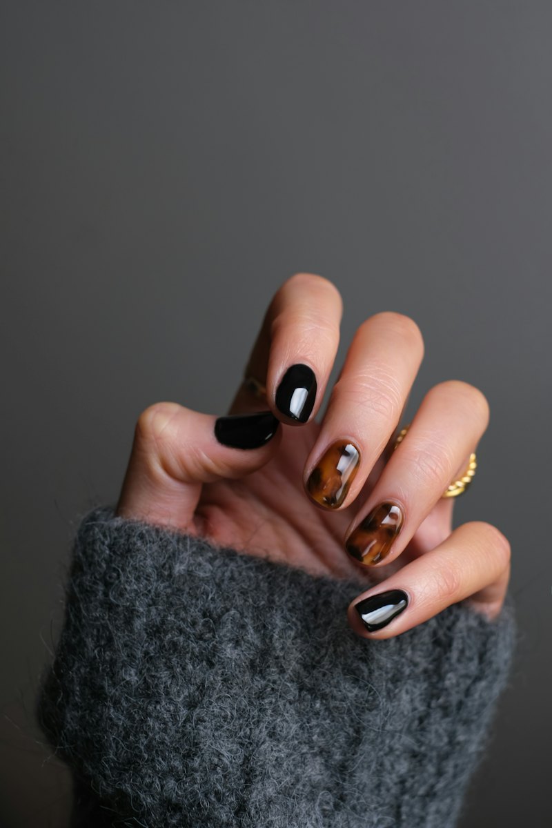 A gel manicure in glossy black and tortoiseshell