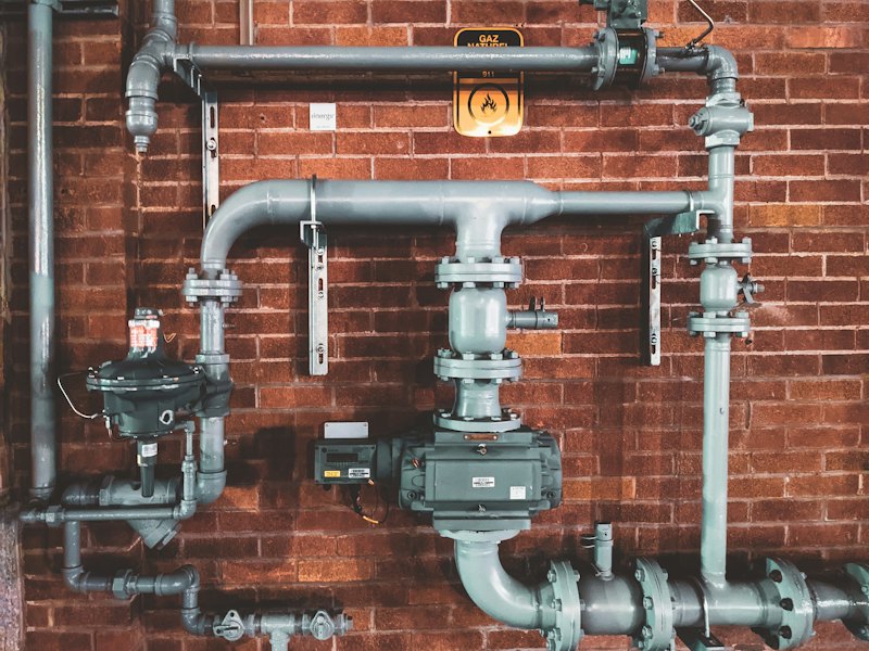 Copper and steel pipework fixed to a brick wall